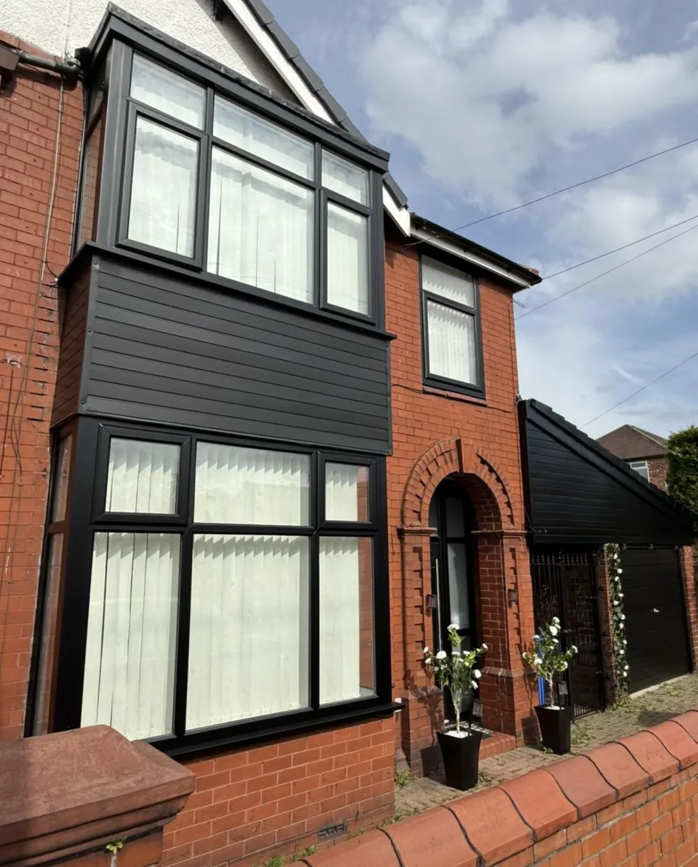 House exterior with UPVC windows and cladding sprayed black