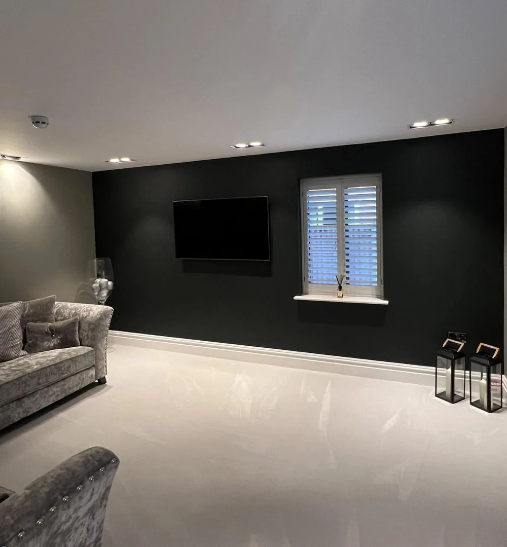Lounge with a deep charcoal feature wall behind a wall-mounted television