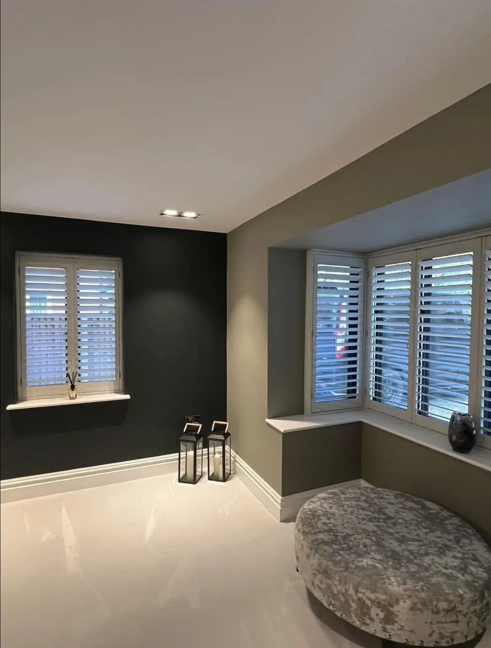 Living room with dark green walls, white shutters and crisp white skirting
