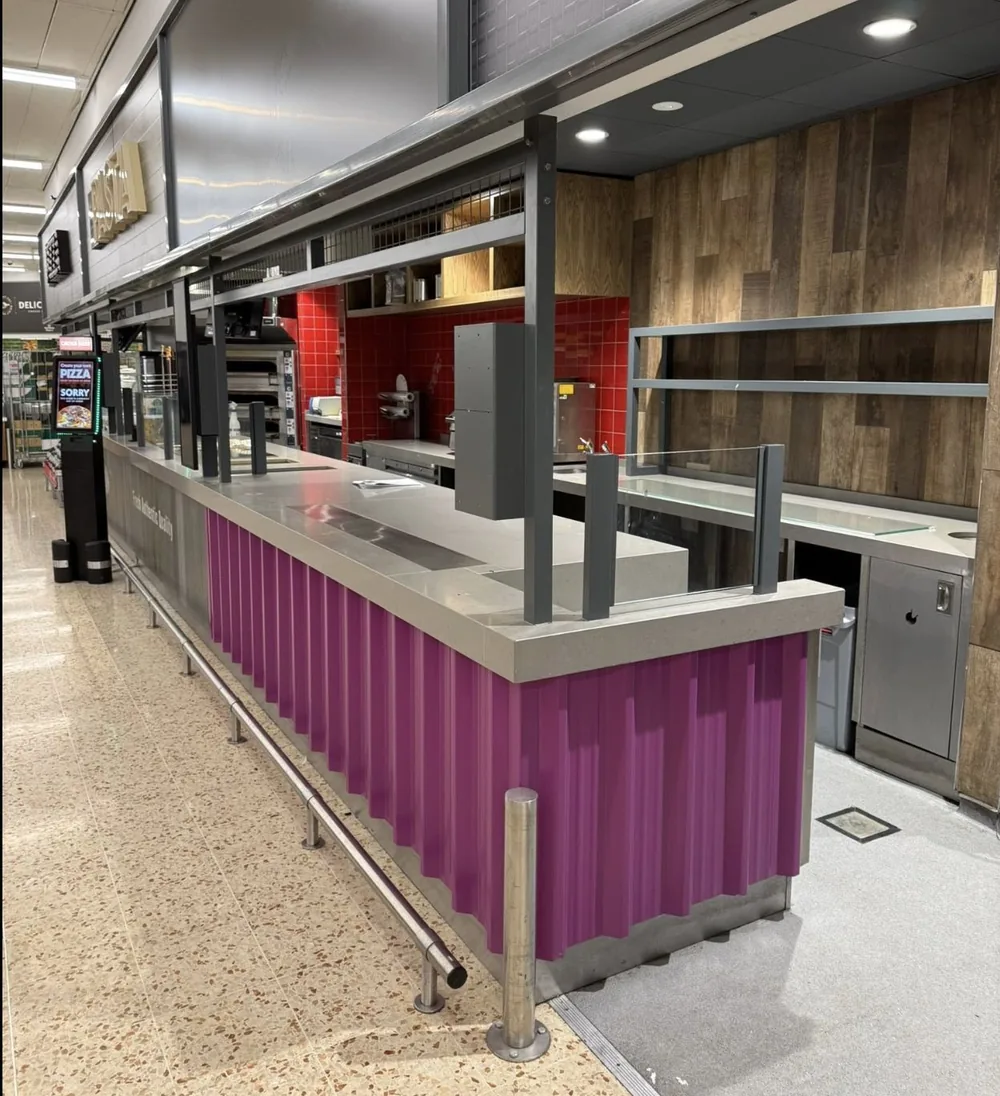 Supermarket deli and pizza counter with sprayed cladding